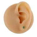 Detailed view of a turtle stud earring in gold with green zircon on a model ear - Gold Turtle Style (B1409)