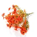 Detail von lebensechten orangefarbenen Kunstblumen mit schwarzen Staubgefäßen und Blättern - Herbstorange