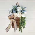 Rustic wicker door basket with white roses and eucalyptus on a white wooden background - White