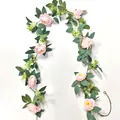 Detail van kunstmatige roze rozenrank met dichte groene bladeren en witte bloemen - Camellia Wijnstok / Roze