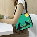 Teal shoulder bag with black cat illustration and adjustable strap on white model - Two Cats Moon Teal BG (13)