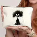 Canvas makeup bag with black poodle print and zipper closure held by a model - Black Puppy (5)