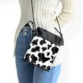 Minimalist crossbody phone bag featuring black and white cow print with thin shoulder strap - Black and White Cow Spotted