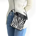 Crossbody phone bag with zebra print contrast design and slim black shoulder strap - Black and White Spliced Zebra
