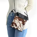 Crossbody phone bag featuring cow print canvas with black trim and a rope strap - Brown And White Cow Print