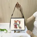 Chic cream tote bag featuring a floral letter R print and adjustable black strap - S / R18 (Letter R)