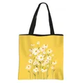 Vibrant yellow floral tote bag featuring a dense daisy pattern and black shoulder straps - Yellow Daisy