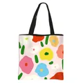Floral print polyester tote bag in light pink with black handles and vibrant pattern - Colorful Flowers