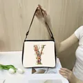 Minimalist tote bag featuring a floral letter Y print and adjustable black shoulder strap - Y25 (Letter Y)