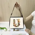 Chic cream tote bag with black strap and artistic floral letter U print design - U21 (Letter U)