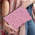 Pink makeup bag with black heart patterns and zipper closure held by a model - Pink Heart Style (01)