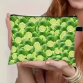 Süße Kosmetiktasche mit Limettendruck, Reißverschluss und Schlaufe, von Modell gehalten - Limettenscheibenmuster (04)