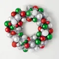 Christmas wreath made of red, green, white, and silver decorative balls on white background - Red & Green