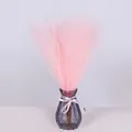 Detail of pink faux pampas grass in a grey glass vase with decorative ribbon bow - Light Pink