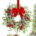 Détail de couronne de Noël avec aiguilles de pin enneigées, baies rouges et pommes de pin - Style Nœud