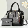Glossy black crocodile pattern handbag set with golden cat pendant and tassel detail - Black