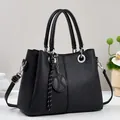 Elegante schwarze Handtasche mit geometrischer Prägung, Doppelgriffen und Schultergurt - Schwarz