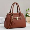 Brown embossed leather tote bag with gold padlock and decorative braided strap ornament - Earthy Yellow