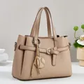 Macro detail of beige tote bag showing geometric textured embossing and fringe tassel - Khaki