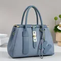 Elegant misty blue handbag with geometric maze embossing and golden lock hardware - Blue