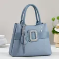Detail der hellblauen Kunstleder-Handtasche mit geometrischem Muster und Strass-Schnalle - Blau