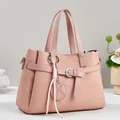 Detail of pink leather handbag showing geometric embossed texture and tassel charm - Pink