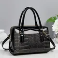 Détail du cuir verni noir et de la texture crocodile grise sur un sac à bandoulière - Noir