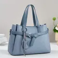 Borsa a mano azzurra con goffratura geometrica, manici e ciondolo a nappa - Blu