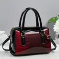 Detail of red and black crocodile embossed patent leather with gold metal hardware - Burgundy