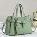 Borsa a mano minimalista verde salvia con motivi geometrici e ciondolo a foglia chic - Verde