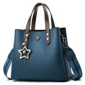 Navy blue bucket bag with brown handles and a gold star charm on a white background - Upgraded Charm Version / Blue