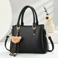 Retro black Boston handbag for women with litchi texture and cute bear pendant charm - Black