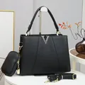 Sac à main chic en cuir litchi noir avec logo V et bandoulière sur un piédestal blanc - Noir