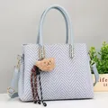 Light blue geometric textured handbag with fuzzy bear charm and adjustable shoulder strap - Blue