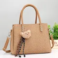 Detail view of khaki woven tote bag with detachable strap and plush bear pendant - Earthy Yellow