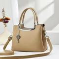 Elegant beige pebbled leather tote bag with heart charm and adjustable shoulder strap - Khaki