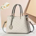 Detail of contrast-color handbag featuring fan-shaped texture and gold flower pendant - Gray Floral