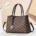 Detailed macro view of vintage brown monogram handbag with gold floral pendant and leather strap - Coffee Floral