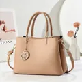 Schicke khakifarbene Handtasche aus Kieselleder mit goldenem Blumenanhänger und Gurt - Khaki