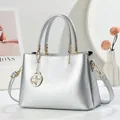 Sac à main argenté en cuir grainé avec détails dorés et pendentif floral élégant - Argent