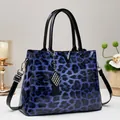 Elegante handtas van blauw lakleer met luipaardprint en zilveren V-vormige hardware - Blauw