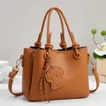 Elegant brown pebble leather handbag with knot handles and cute dog charm ornament - Earthy Yellow