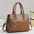 Elegant brown leather tote bag with leaf pearl pendant and metal Tenatoz logo - Brown