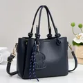 Navy blue lychee grain leather handbag with adjustable strap and cute puppy charm - Blue
