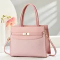 Elegant pink leather tote bag with woven texture, golden turn-lock, and twin handles - Pink
