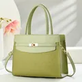Detail of light green handbag featuring woven texture and gold metal turn-lock closure - Green