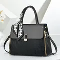 Detail of black tote bag with textured pleats, gold hardware and houndstooth scarf handle - Black
