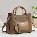 Detail of wheat texture leather handbag with heart charm and Fashion Queen logo - Khaki