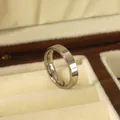 Close-up of a 4mm polished silver stainless steel ring in a luxury wood jewelry box - US 6 / Silver
