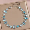 Nahaufnahme von Silberarmband mit blauen Zirkonia auf champagnerfarbenem Metallständer - Hellblauer Fantasie-Edelstein Silber Stil (DQ-W-3289-1) / 18cm